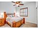 Cozy bedroom featuring a wooden bed frame, window with shutters, and side table with a lamp at 14302 W Laurel Ln, Surprise, AZ 85379