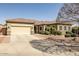 Charming single-story home with a two-car garage, desert landscaping, and a beautiful tile roof at 14302 W Laurel Ln, Surprise, AZ 85379