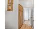 Hallway with wood-look flooring, framed artwork, and an open doorway at 14302 W Laurel Ln, Surprise, AZ 85379