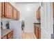 Laundry room with modern washer and dryer, wood cabinets, and granite countertops at 14302 W Laurel Ln, Surprise, AZ 85379