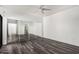 Bright bedroom features wood-look floors, a ceiling fan, and mirrored closet doors at 15225 N 100Th St # 2210, Scottsdale, AZ 85260
