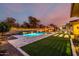 Expansive backyard featuring a pool, outdoor kitchen, grassy area, and manicured landscaping, creating a serene retreat at 15936 W Bonitos Dr, Goodyear, AZ 85395