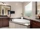 Bright bathroom with a soaking tub, neutral colors, and dual sink vanity with granite countertops at 15936 W Bonitos Dr, Goodyear, AZ 85395
