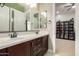 Bathroom featuring dual sinks with a granite countertop and view to a bonus room at 15936 W Bonitos Dr, Goodyear, AZ 85395