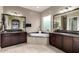 Bright bathroom featuring dual sinks with granite countertops and a relaxing soaking tub at 15936 W Bonitos Dr, Goodyear, AZ 85395