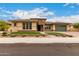 Charming single-story home with a well-manicured lawn, colorful flowers and lush green grass at 15936 W Bonitos Dr, Goodyear, AZ 85395