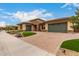 Beautiful home with green lawns, paver driveway, and well-maintained landscaping at 15936 W Bonitos Dr, Goodyear, AZ 85395