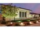 Exterior view of home at twilight with manicured front lawn, flower bed, and decorative lighting at 15936 W Bonitos Dr, Goodyear, AZ 85395