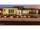 Exterior view of home at twilight with manicured front lawn, flower bed, and decorative lighting at 15936 W Bonitos Dr, Goodyear, AZ 85395
