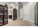 Hallway with view to bathroom, showcasing neutral paint, carpet and large toy display cases at 15936 W Bonitos Dr, Goodyear, AZ 85395