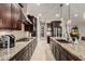 Modern kitchen with granite countertops and stainless steel appliances and dark cabinets at 15936 W Bonitos Dr, Goodyear, AZ 85395
