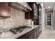 Stylish kitchen with granite counters, tile backsplash, and stainless steel range hood at 15936 W Bonitos Dr, Goodyear, AZ 85395