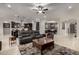 Open-concept living room and kitchen featuring dark cabinets and a modern ceiling fan at 15936 W Bonitos Dr, Goodyear, AZ 85395
