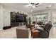 Spacious living room with cozy furniture, a large entertainment center and tile flooring at 15936 W Bonitos Dr, Goodyear, AZ 85395