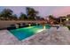Inviting pool with travertine tile, water features, and an outdoor seating area, perfect for relaxation at 15936 W Bonitos Dr, Goodyear, AZ 85395