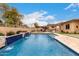 Inviting pool with waterfall features and a covered outdoor kitchen perfect for relaxation and entertaining at 15936 W Bonitos Dr, Goodyear, AZ 85395
