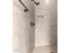 Walk-in shower featuring tile surround, updated fixtures, and convenient built-in niche at 15936 W Bonitos Dr, Goodyear, AZ 85395