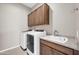 Functional laundry room with washer, dryer, overhead cabinets, and a sink with countertop space at 18837 N Cook Dr, Maricopa, AZ 85138