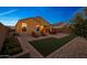 Private backyard features a well-manicured artificial turf area, paver patio, and colorful landscaping at 2330 E Lieber Pl, Phoenix, AZ 85024