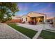 Serene backyard with a covered patio, desert landscaping, and low-maintenance artificial turf at 2330 E Lieber Pl, Phoenix, AZ 85024
