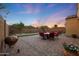 A backyard patio with a grill, seating, and a beautiful sunset in the background, perfect for outdoor dining and relaxation at 2330 E Lieber Pl, Phoenix, AZ 85024