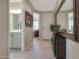 Well-lit hallway with a large decorative mirror, leading to the bathroom and a bright, welcoming entrance at 2330 E Lieber Pl, Phoenix, AZ 85024