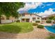 Expansive backyard featuring lush lawn, a sparkling pool, and serene desert landscaping at 2551 E Buena Vista Pl, Chandler, AZ 85249
