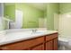 Bathroom featuring a light wood vanity, bright green walls, a shower-tub combo, and a white door at 2551 E Buena Vista Pl, Chandler, AZ 85249