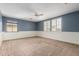 Spacious carpeted bedroom with blue walls, ceiling fan and shuttered window at 2551 E Buena Vista Pl, Chandler, AZ 85249