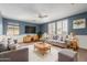 Cozy living room with blue walls, wood trim, a ceiling fan, and comfortable seating, creating a relaxing atmosphere at 2551 E Buena Vista Pl, Chandler, AZ 85249
