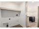 Bright laundry room with floating shelf, washer hookups and adjacent to kitchen with island and recessed lights at 2650 W Union Hills Dr # 123, Phoenix, AZ 85027