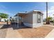Well-maintained home featuring covered entry and gray siding under a clear blue sky at 2650 W Union Hills Dr # 91, Phoenix, AZ 85027