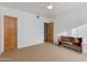 Spacious bedroom with a ceiling fan, a bench, and a lovely wooden door at 27171 N 73Rd St, Scottsdale, AZ 85266