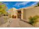 Inviting front entrance featuring a wrought iron gate, desert landscaping, and a paved walkway at 27171 N 73Rd St, Scottsdale, AZ 85266