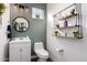 Charming powder room with modern fixtures, decorative mirror, open shelving, and a stylish sink at 3438 E Betsy Ln, Gilbert, AZ 85296