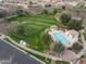 Aerial view of community pool with shade structure, lounge chairs, landscaping, and nearby green space at 3438 E Betsy Ln, Gilbert, AZ 85296