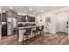 A kitchen features dark wood cabinets, a stainless steel fridge, backsplash, and an island with bar seating at 3438 E Betsy Ln, Gilbert, AZ 85296
