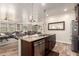 Kitchen island featuring barstool seating and a sink area, seamlessly connecting to the adjacent dining and living spaces at 3438 E Betsy Ln, Gilbert, AZ 85296