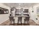 A kitchen features dark wood cabinets, a stainless steel fridge, a backsplash, and an island with bar seating at 3438 E Betsy Ln, Gilbert, AZ 85296