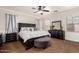 A main bedroom featuring a dark wood bed frame, matching furniture set, and neutral walls and carpet at 3438 E Betsy Ln, Gilbert, AZ 85296