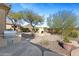 A stunning backyard fireplace with built-in seating surrounded by lush landscaping and a stainless steel grill at 41601 N River Bend Rd, Anthem, AZ 85086