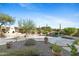 The backyard oasis has a large rock water feature, a firepit and manicured desert landscaping at 41601 N River Bend Rd, Anthem, AZ 85086