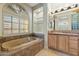 Relaxing bathroom with a soaking tub, natural light, and a vanity with storage at 41601 N River Bend Rd, Anthem, AZ 85086