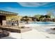 Community pool area features shaded seating, lounge chairs and a well-maintained pool with desert landscaping at 41601 N River Bend Rd, Anthem, AZ 85086