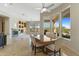 Dining area with a large table, floor-to-ceiling windows, fireplace, and desert views at 41601 N River Bend Rd, Anthem, AZ 85086