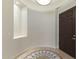 Elegant foyer featuring a decorative tile inlay, recessed lighting, and a dark wood front door at 41601 N River Bend Rd, Anthem, AZ 85086