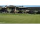 Scenic view of a golf course with putting green and distant clubhouse at 41601 N River Bend Rd, Anthem, AZ 85086