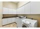 Well-equipped laundry room featuring modern washer and dryer, ample cabinet and counter space at 41601 N River Bend Rd, Anthem, AZ 85086