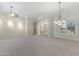 Expansive living room with plush carpeting, modern light fixtures, and custom trim throughout at 41601 N River Bend Rd, Anthem, AZ 85086