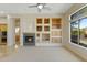 Cozy living room with fireplace, built-in shelves, and a large window at 41601 N River Bend Rd, Anthem, AZ 85086